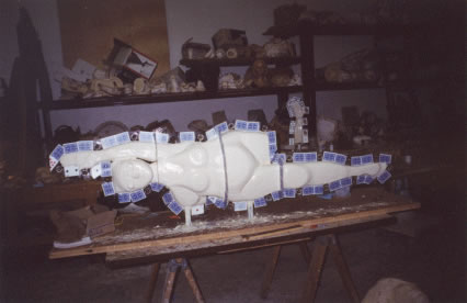 Rubber coating covering the clay sculpture. Cards are added to create a seam for the mold.